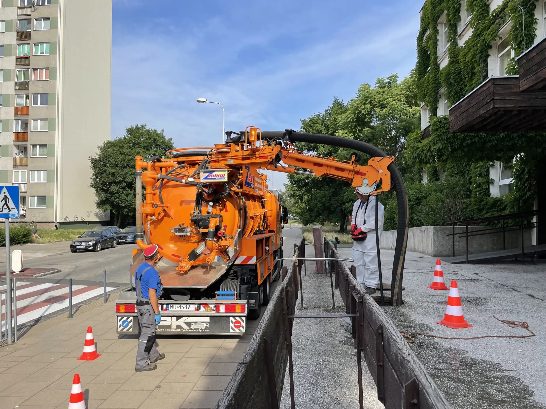 Samochód WUKO podczas czyszczenia ciśnieniowego przy budynku we Wrocławiu